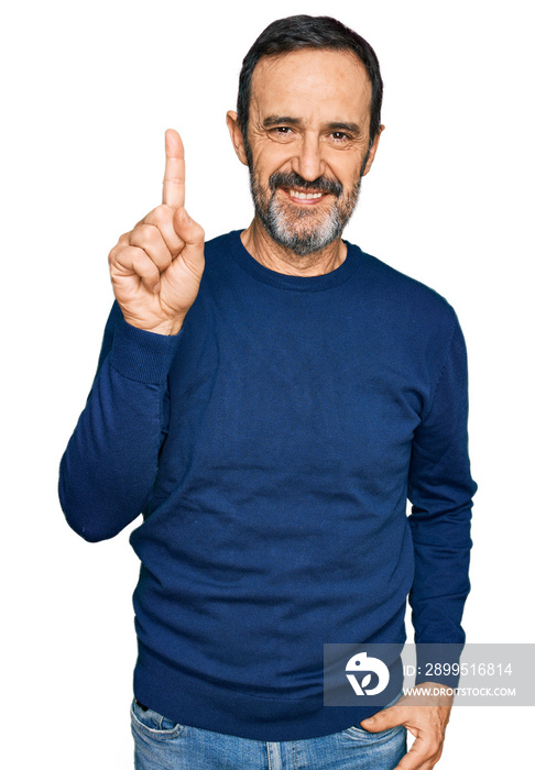 Middle age hispanic man wearing casual clothes showing and pointing up with finger number one while smiling confident and happy.