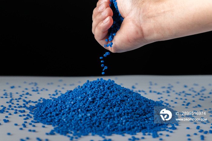 Blue plastic beads on wood  background, Polymers bead or polymer resin, polymer pallet, Product from petrochemical plants. granules polymer, Concept roof of house is made of polymer plastic.