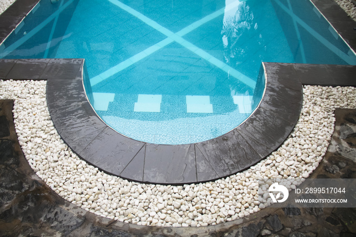 curve swimming pool gutter with white gravels on top and black slate border, pool side coping materials