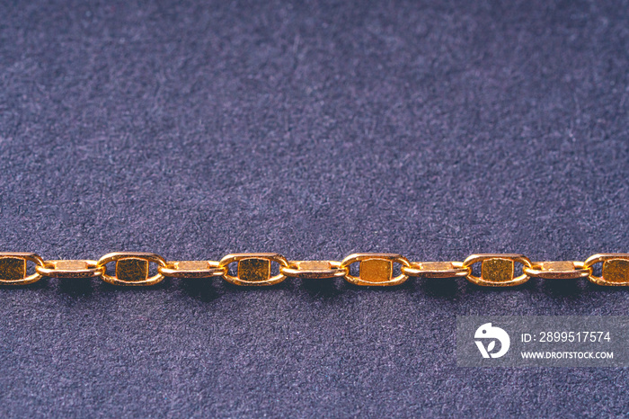 A fragment of yellow gold chain close up.