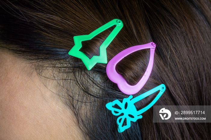 Colored hair clips that are attached to a woman’s hair.