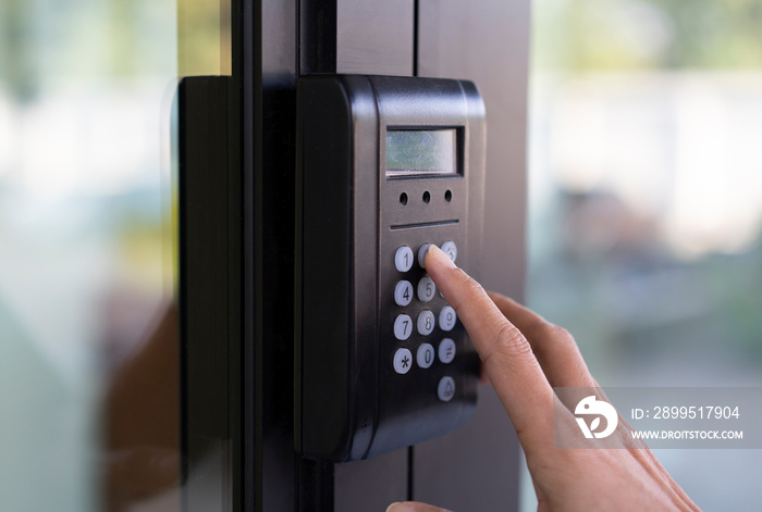 Businesswoman press number buttons for password and match fingerprint to access an office building.