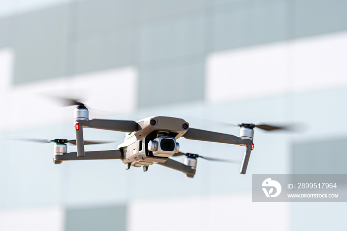 Drone flying overhead in sky over the roof of the city