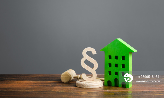 Green house and paragraph figurine with a judge hammer. Litigation in housing and real estate disputes. Norms and rules for construction, maintenance. Encouraging green and energy-saving technologies.