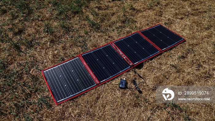 A foldable, portable solar panel open on a lawn