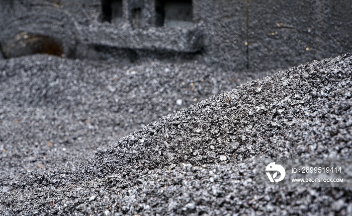 Selective focus of asphalt pile in asphalt paver’s container for road construction work, material in construction concept