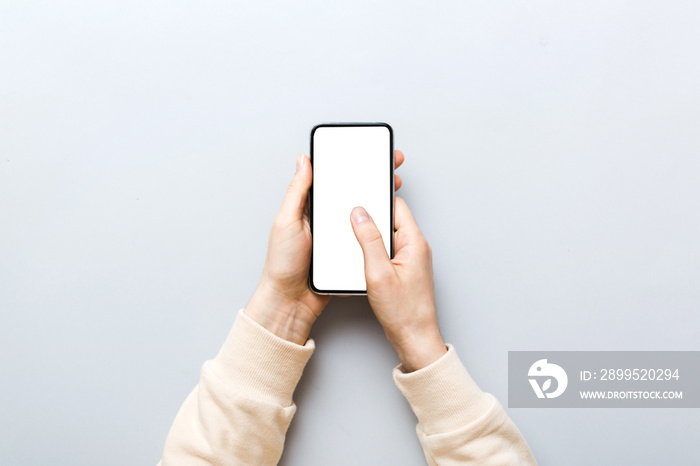 Top view of woman hands holding smart phone with blank copy space screen for your text message or information content. woman hand using phone white screen on top view