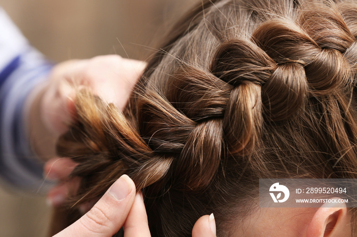 Professional hairdresser braiding clients hair