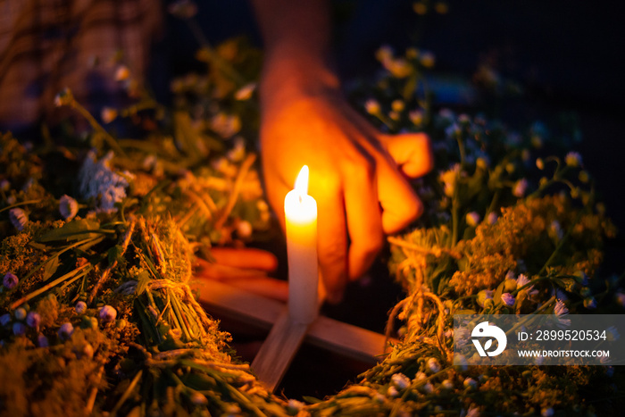 Close-up shot of a kupala wreath in girl`s hands on the river. Floating ritual wreath on the river with a candle, Ivan kupala celebration