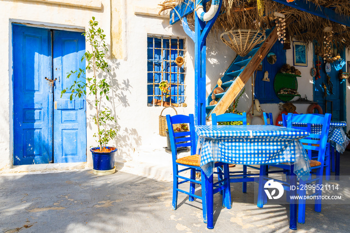 Table in front of typical Greek house on street of Finiki village, Karpathos island, Greece