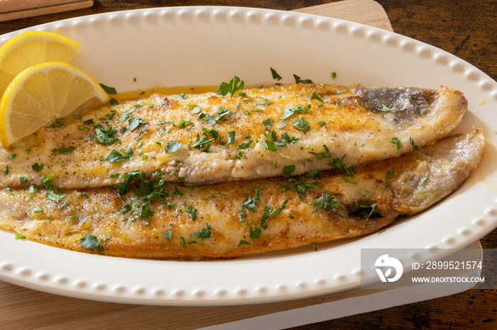 baked fish with lemon and herbs in dish