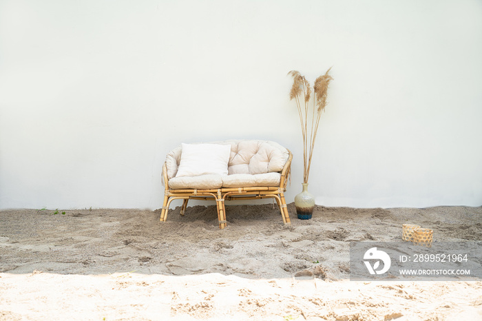 Boho eco styled beach essentials on sand by sea.