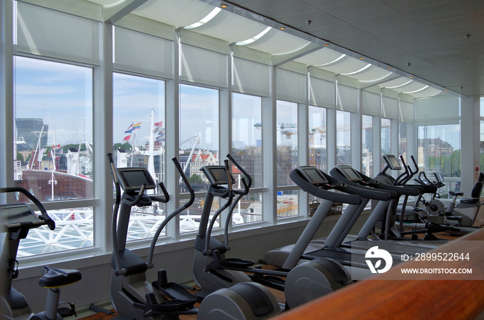 Moderner Fitnessbereich auf Luxus-Kreuzfahrtschiff mit Blick auf Skyline von Hamburg