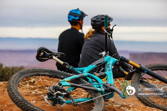 A Young Mountain Biking Couple Takes A Minute To Take In The Scenery