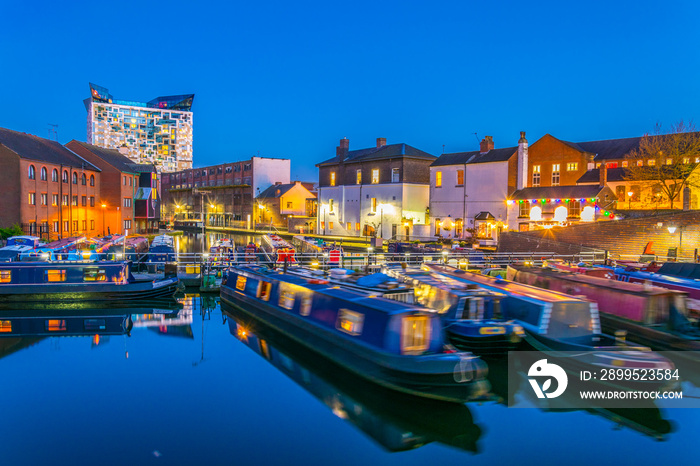 The cube behind brick buildings alongside a water channel in the central Birmingham, England