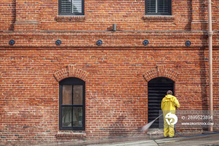 washing street sidewalk with a hose