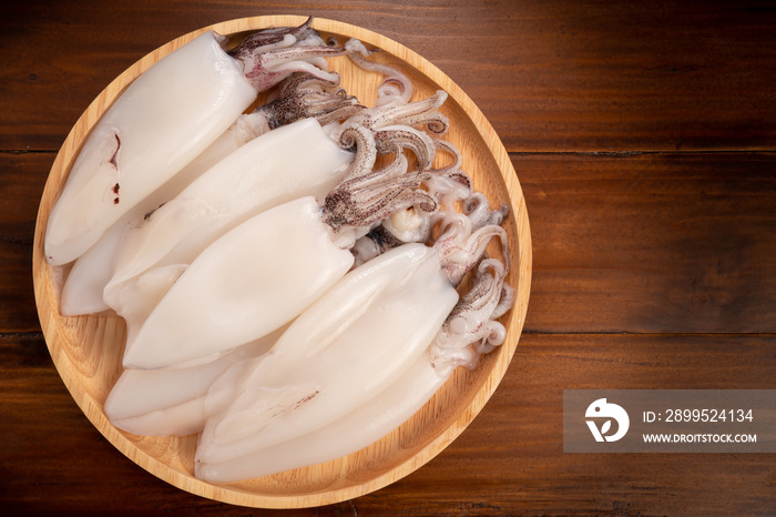 Fresh Squid in wooden plate on wooden background, Fresh Splendid Squid on wooden plate.