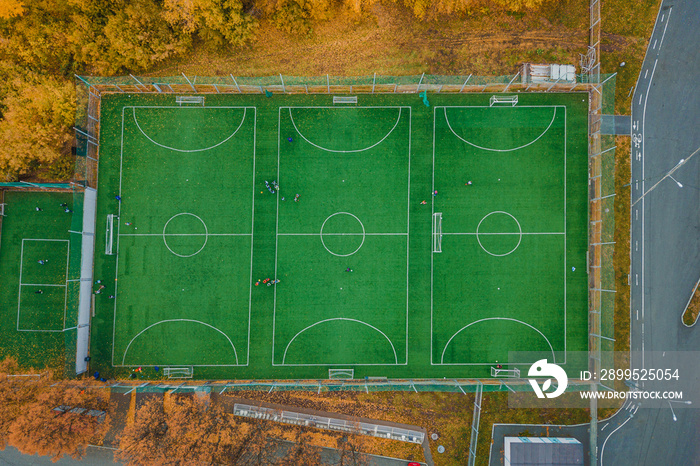 Aerial view of amateur mini football playground with practicing and training sportsmans