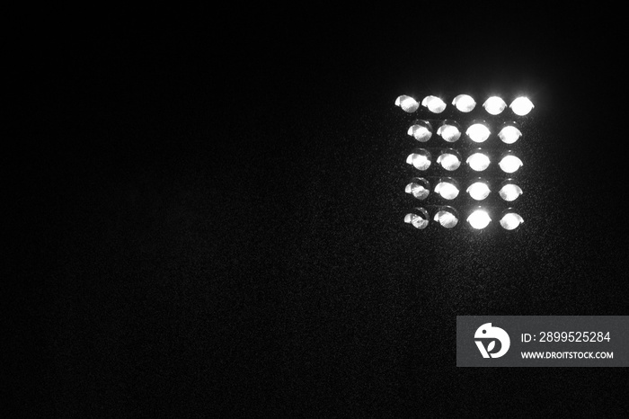 Spotlight of football stadium at night with dark background.