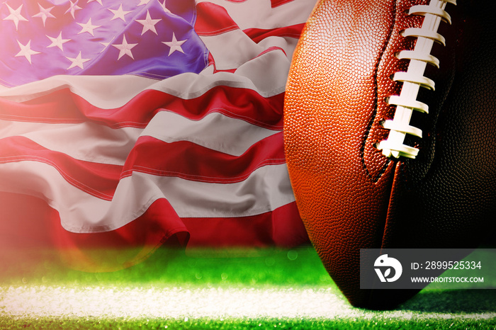 American football on green grass, on flag of United States of America background