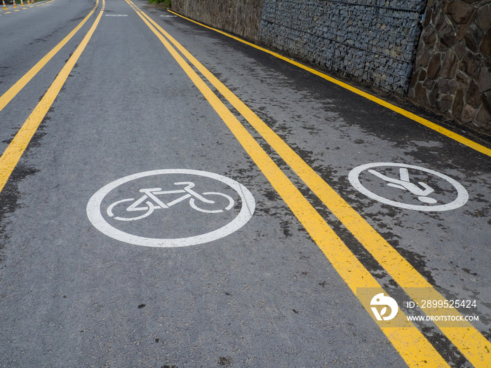 The walking and cycling paths in city are separated from each other with yellow lines. White road markings for pedestrians and cyclists. Infrastructure for walking and physical activity on the street