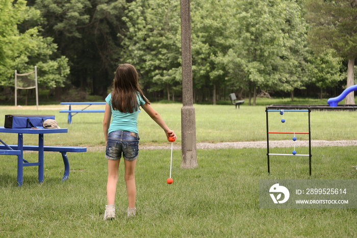 Girl plays ladder toss in public park