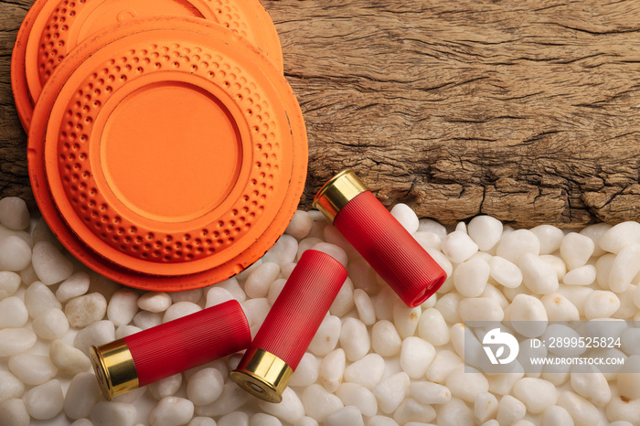 Clay disc flying targets and shotgun bullets on wooden background ,Clay Pigeon target