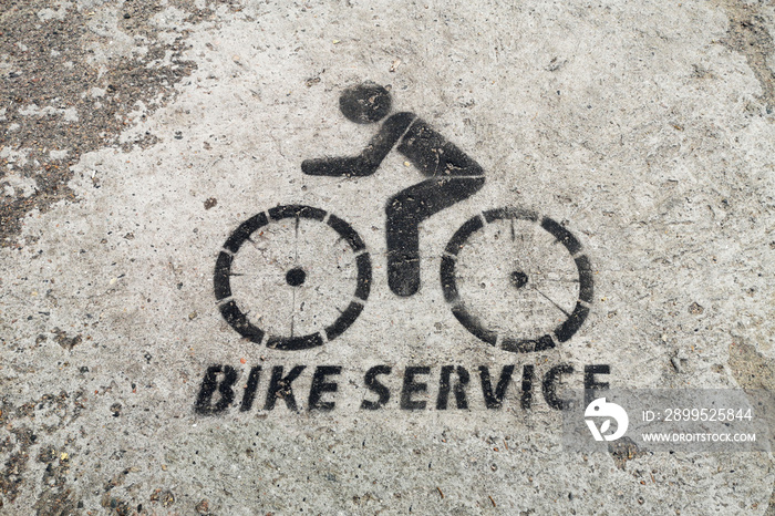 Black bicycle repair station sign on asphalt. Bicycle lane signage on street