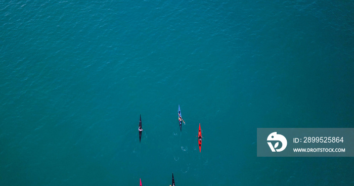 Aerial image of kayakers paddling forwards. Sport canoes and Kayaks at sea.