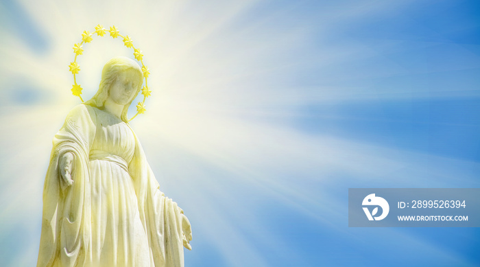 Virgin Mary is Queen of heaven in the light rays. Ancient statue.