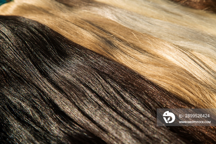 strands of natural women’s hair for encapsulation and extension in a beauty salon.