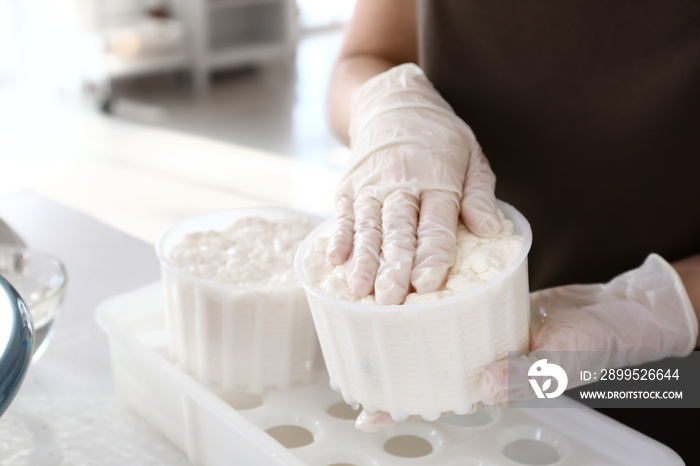 Woman preparing tasty cheese in kitchen, closeup