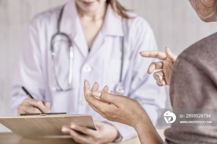 female patient talking and explaining about health problem to the doctor at a hospital