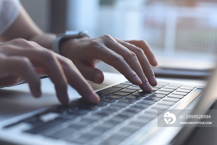 Woman hands typing on laptop computer keyboard