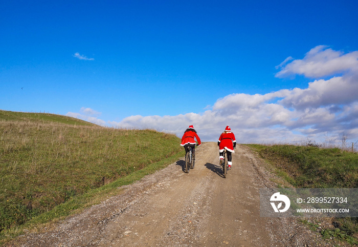 Donne cicliste vestite da bbabbo natale in bici per la campagna toscana