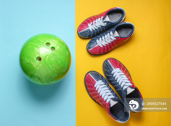 Bowling shoes and bowling ball on blue yellow background. Indoor family sports. Top view. Minimalism