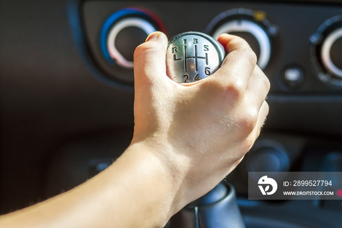 Driver hand shifting gear shift knob manually, selective focus