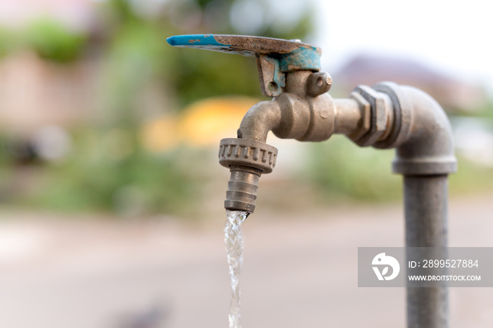 Old water tap with flowing of water