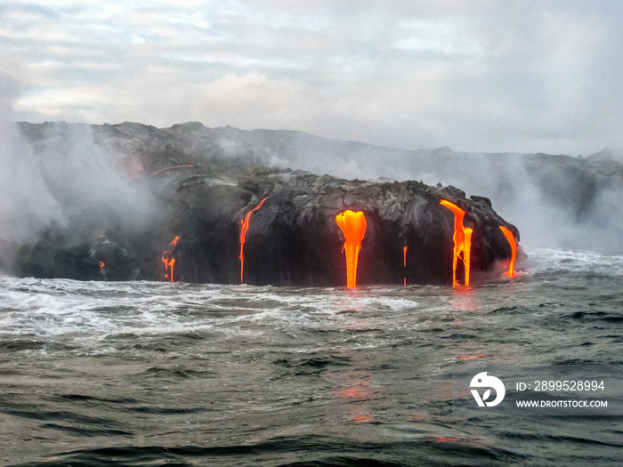 Scenic sea view from the boat of Kilauea Volcano in Hawaii Volcanoes National Park, while erupting lava into Pacific Ocean, Big Island, Hawaii.