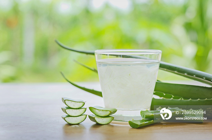 fresh aloe vera leaves and aloe vera juice in glass on wooden background