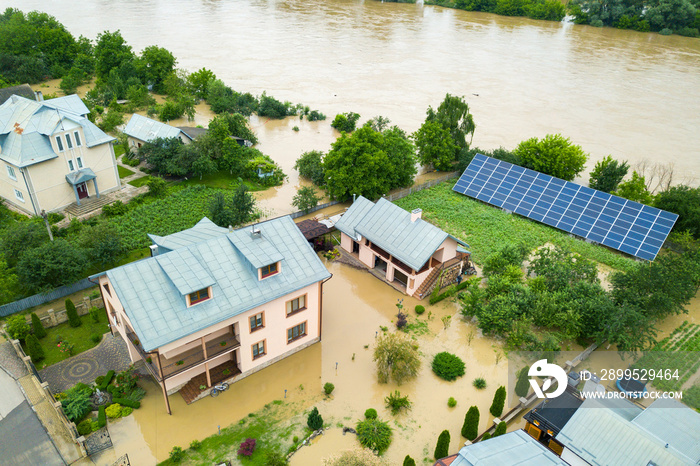 Aerial view of flooded house with dirty water all around it.