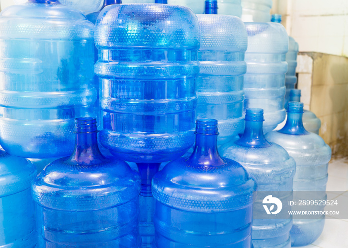 Blue plastic bottles or blue gallons of drinking water are stacked in the drinking water factory to cycle the drinking water.water factory  business concept