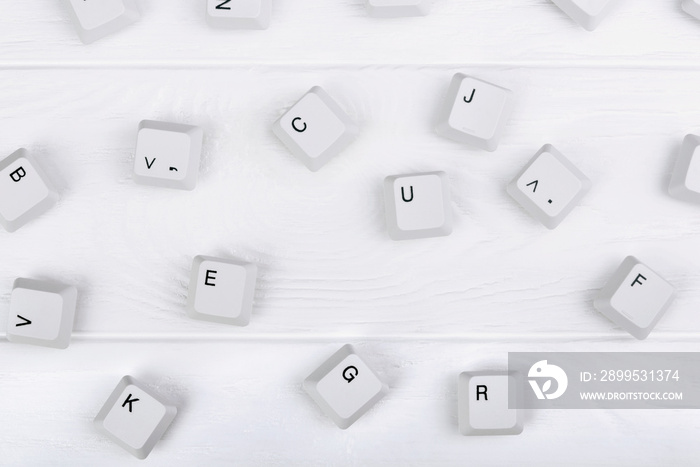 Keyboard keys isolated. White keyboard keys on white wooden background. Top view. Close up