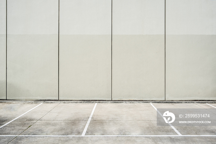 Empty parking lot next to concrete wall - clean geometric architecture shapes with copy space