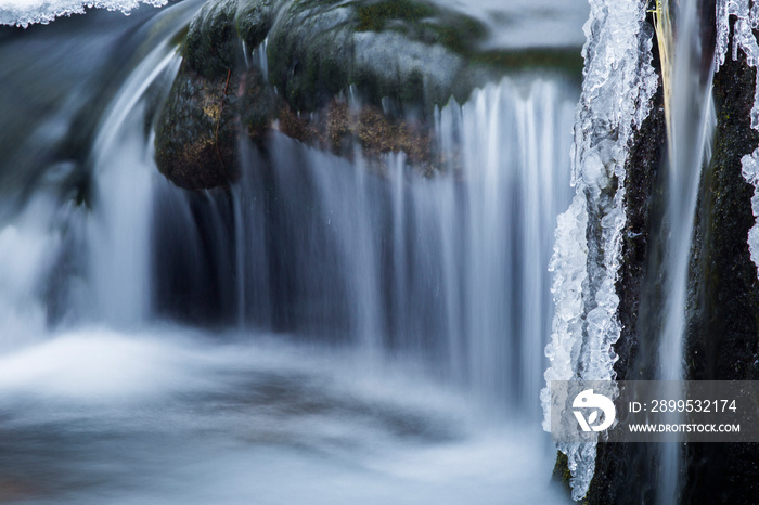 details of a frozen creek in heavy winter