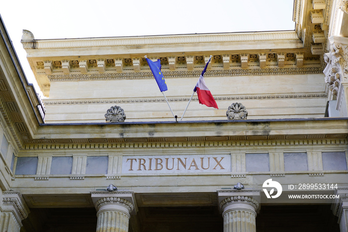 tribunaux text on ancient wall facade building means in french law courts with france european flag