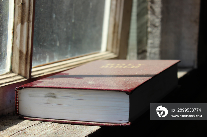 dusty bible book on wooden table