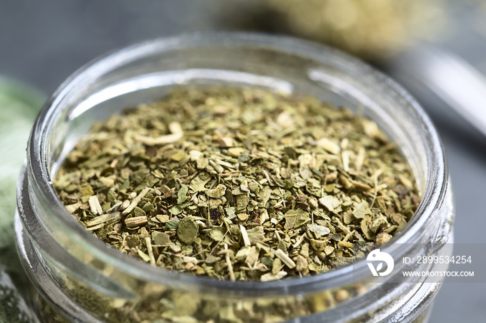 Dried leaves of yerba mate tea, a traditional tea in South-America, photographed in glass jar on slate (Selective Focus, Focus one third into the tea leaves)