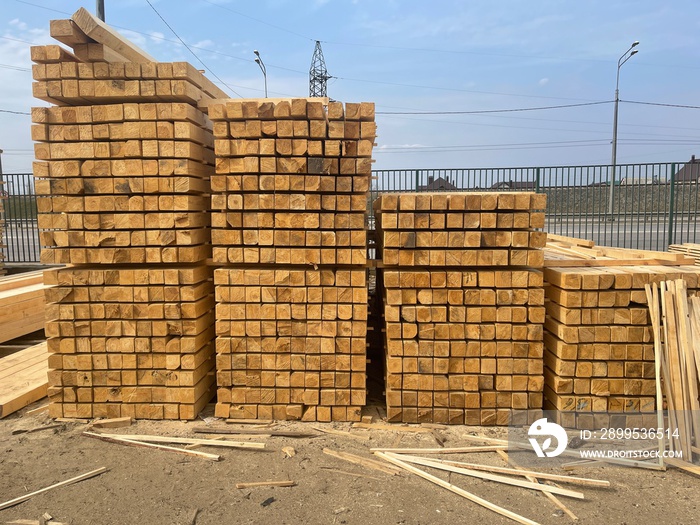 Wooden boards, lumber, industrial wood, timber. Pine wood timber stack of natural rough wooden boards on building site. Industrial timber building materials