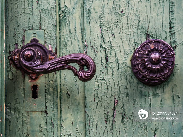 Closeup of the doorknob on the old green door